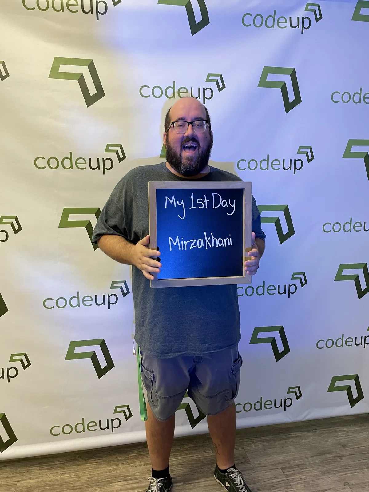 Ben Campbell on his first day at Codeup in front of a branded backdrop