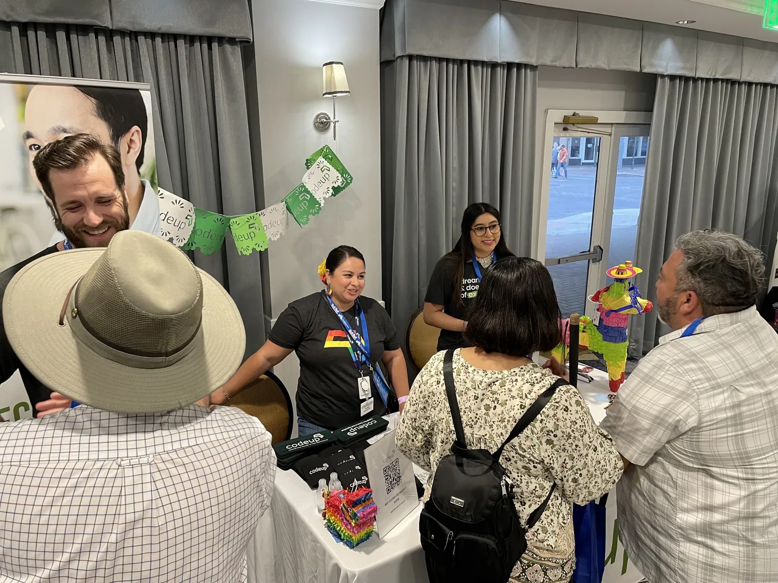 Codeup team speaking with attendees at a community event